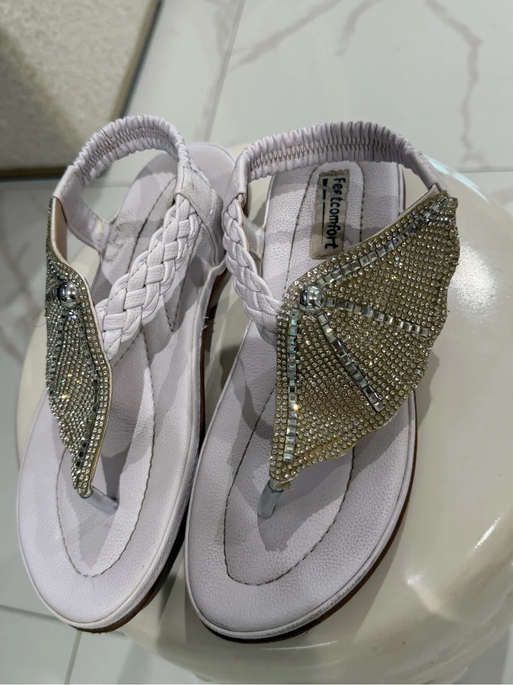 White rhinestone sandals with braided straps.